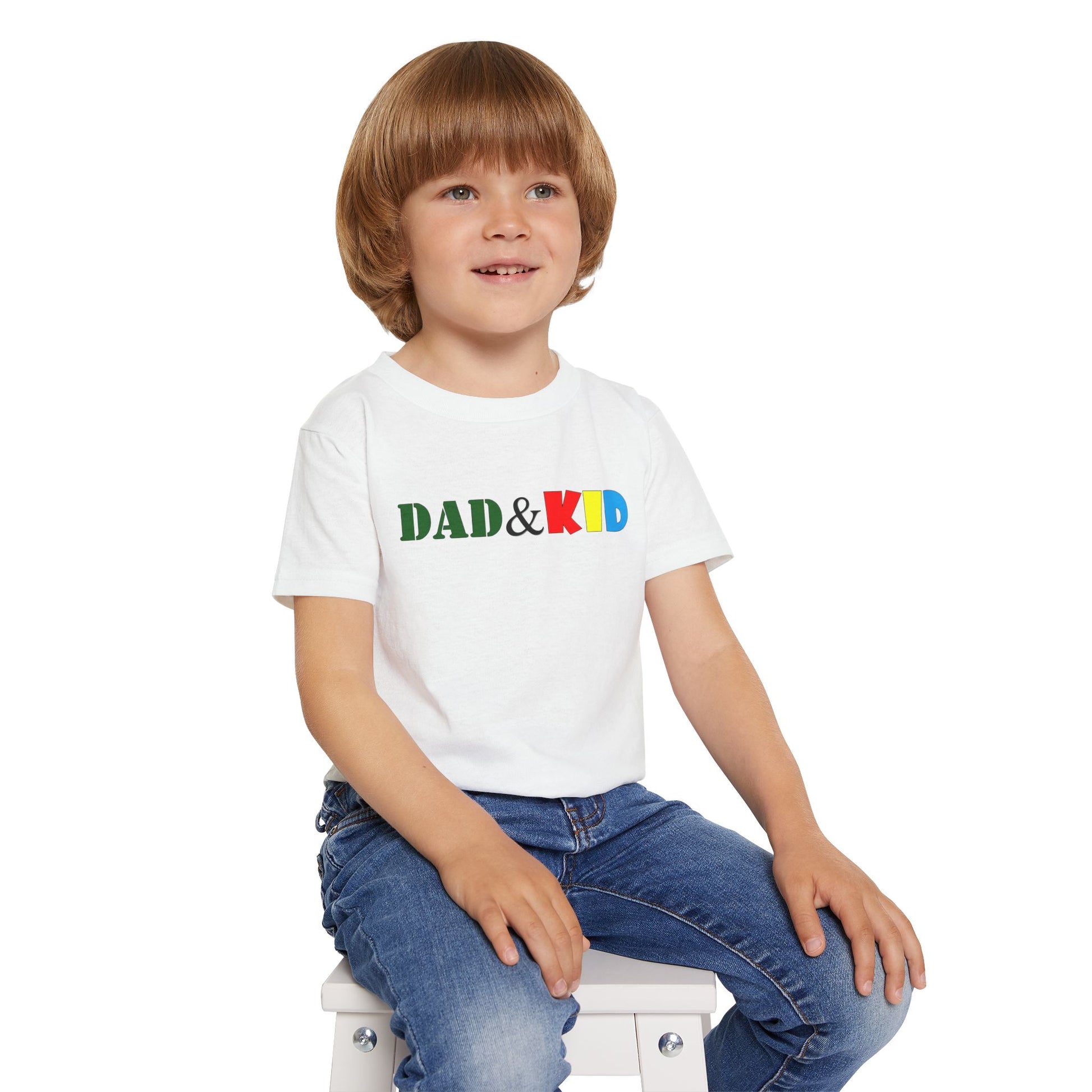 Child wearing a white t-shirt with 'DAD & KID' text in colorful letters on a white background
