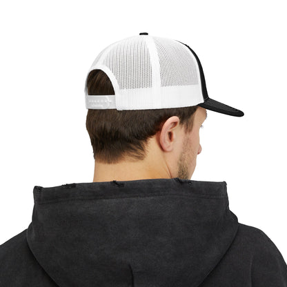 Person wearing a black hoodie and a white and black cap on a white background